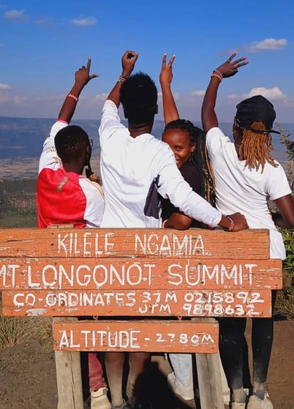 Four HikeQuest hikers at the Mount Longonot summit signboard, altitude 2,780 metres